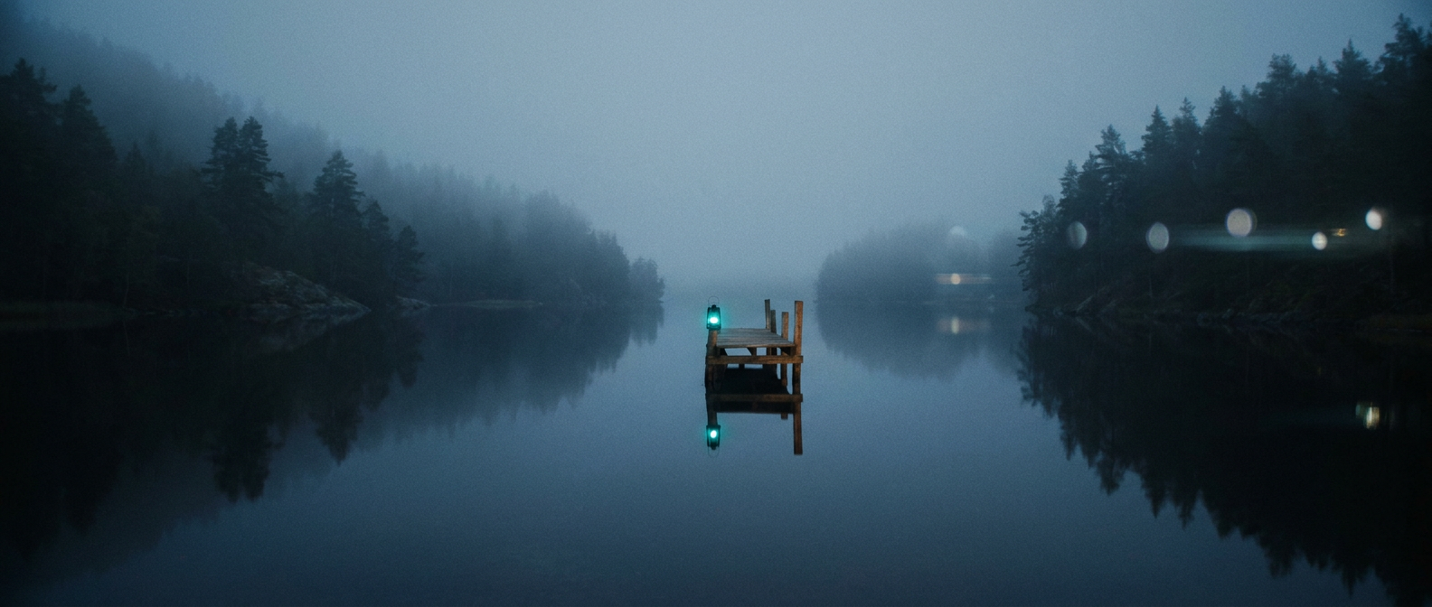 Fjord — stilla fjord i gryningsdis med teal lykta